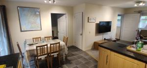 sala de estar con mesa y cocina con TV en The Cobbler Cottage - Loch Lomond and Arrochar Alps, en Arrochar