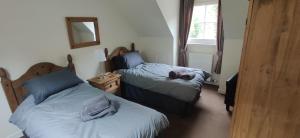 una camera da letto con due letti e uno specchio sul muro di The Cobbler Cottage - Loch Lomond and Arrochar Alps ad Arrochar