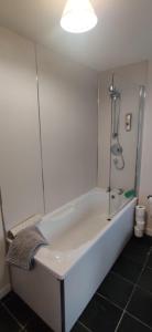 e bagno con vasca bianca e doccia. di The Cobbler Cottage - Loch Lomond and Arrochar Alps ad Arrochar Altre 7 foto