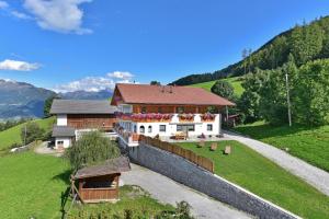 a house on a hill next to a fence at Joselehof App Enzian in Stanghe