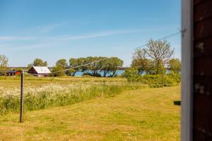 Blick auf ein Feld mit einem Zaun und einem Haus in der Unterkunft Fårösunds Semesterby in Fårösund