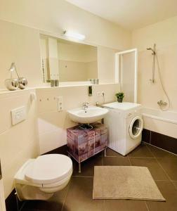 ein Badezimmer mit Toilette, Waschbecken und Waschmaschine in der Unterkunft Edle Ferienwohnung - Industrial Style in Dresden
