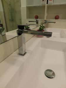 uma casa de banho com um espelho e um lavatório de prata em Quinto Canto Moneglia em Moneglia