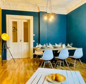 a dining room with blue walls and a table and chairs at Edle Ferienwohnung - Industrial Style in Dresden