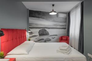 1 dormitorio con 1 cama blanca y 1 silla roja en Shabbat Apartments, en Bucarest