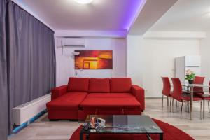 sala de estar con sofá rojo y mesa en Shabbat Apartments, en Bucarest
