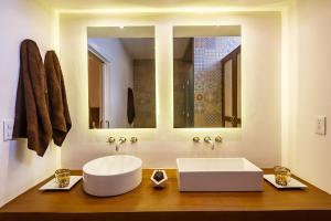 La salle de bains est pourvue d'un lavabo blanc et d'un miroir. dans l'établissement HM Playa del Carmen, à Playa del Carmen