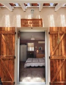 a bedroom with wooden doors and a bed at Le Jardin des Selves in Draguignan