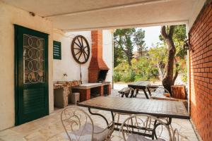 a patio with a table and chairs and a door at Barba Zoran in Bol