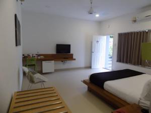 a bedroom with a bed and a desk and a chair at SWISS COUNTY in Idukki