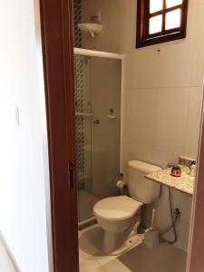 a bathroom with a toilet and a glass shower at Casa Charme de Lençois in Lençóis +10 photos