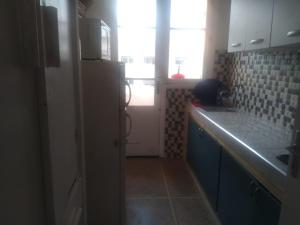 a small kitchen with a refrigerator and a sink at Siwar in Rabat