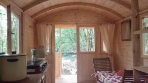 eine Holzhütte mit einem Tisch und Stühlen in der Unterkunft Lovely shepherds hut in chauminet in Sougères-en-Puisaye