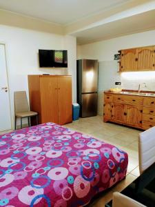 a bedroom with a large bed and a kitchen at Holiday house start point in Aci Bonaccorsi