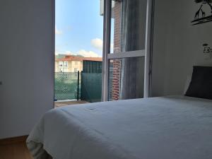 a bedroom with a bed and a large window at La casita de voto in Bádames