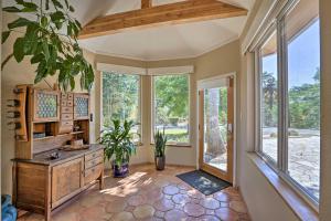 a living room with windows and a wooden dresser at Luxe Auburn Hideaway with Tennis Court and Views! in Auburn