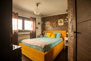 Schlafzimmer mit einem Bett mit einem orangefarbenen Kopfteil in der Unterkunft Amo Bucharest in Bukarest