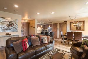 uma sala de estar com um sofá de couro e uma cozinha em Bear Claw 311 - Bear Claw II Building em Steamboat Springs