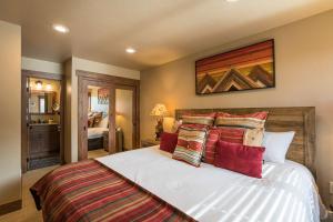 um quarto com uma grande cama branca com almofadas vermelhas em Bear Claw 311 - Bear Claw II Building em Steamboat Springs