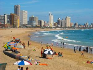 a group of people on a beach near the ocean at Stay at The Point- Royal Relaxing Retreat in Durban