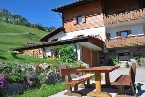 uma mesa de madeira e banco em frente a uma casa em Appartamento Anna & Gino em Sappada