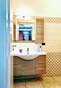 ein Bad mit einem Waschbecken und einem Spiegel in der Unterkunft Holiday house start point in Aci Bonaccorsi