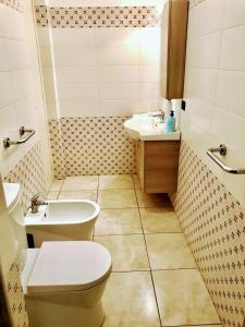 a bathroom with a toilet and a sink at Holiday house start point in Aci Bonaccorsi