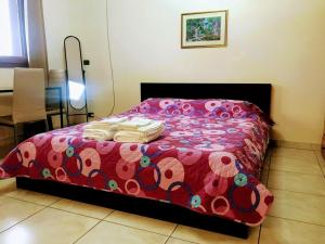 Schlafzimmer mit einem Bett mit einer roten Bettdecke in der Unterkunft Holiday house start point in Aci Bonaccorsi