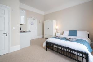a bedroom with a large bed with a blue blanket at The Veteran Hotel & Bar in Ryde