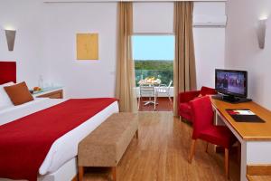 a hotel room with a bed and a desk with a computer at Alcazar Hotel & SPA in Monte Gordo +39 photos