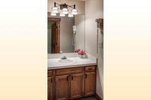 a bathroom with a sink and a mirror at Bear Claw 312 - Ski-in Ski-out Condo! in Steamboat Springs +4 photos