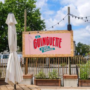 um sinal para um restaurante de gimignite ao lado de um sinal para em Eklo Bordeaux Centre Bastide em Bordeaux