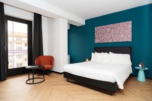 Un dormitorio con una cama grande y una pared azul. en CX Turin Marconi, en Turín