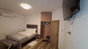 1 dormitorio con 1 cama y TV de pantalla plana en KASNAR ROOMS, en Zagreb