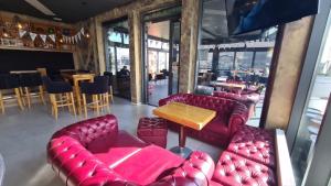 un restaurante con sofás de cuero rojo y una mesa en KASNAR ROOMS, en Zagreb