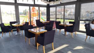 a restaurant with tables and chairs and windows at KASNAR ROOMS in Zagreb