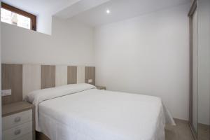 a bedroom with a white bed and a window at La Riega in Potes