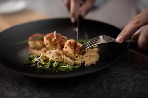 a person eating a plate of food with a fork at Premium Activehotel Bergkönig in Neustift im Stubaital