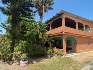 a brick house with a palm tree in the background at CASA inteira entre Guaratiba e Campo Grande, Rio de Janeiro, RJ - a 40 min da praia, próximo ao Estádio Miecimo da Silva e Park Shopping-Ideal para descanso, encontros, festa e lazer-3000 m2 in Rio de Janeiro