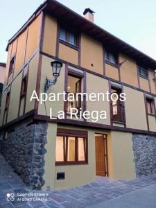 un edificio con un cartel que lee apartamentos la riga en La Riega en Potes