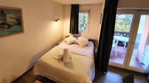 - une chambre avec un lit doté de draps blancs et une fenêtre dans l'établissement La Riviere Vue Mont Blanc, à Chamonix-Mont-Blanc
