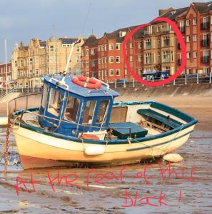 a boat sitting in the water on the beach at Cosy 2-Bed Apartment near the beach in Morecambe in Morecambe