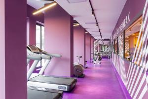 a gym with purple walls and a treadmill at CX Turin Vanchiglia in Turin