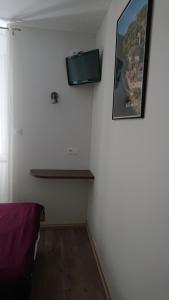 a corner of a room with a tv on the wall at Hôtel de L'Europe in Gramat