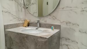 فندق راديانس جراند في أبها: حمام مع حوض ومرآة
