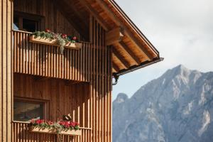 a building with flower boxes on the side of it at Alpine Chalet Sauter in San Vigilio Di Marebbe