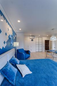 スヴェトロゴルスクにあるBaltic Luxury-52 with Sea viewのベッドルーム(青いベッド1台付)、リビングルーム