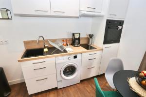 a kitchen with a sink and a washing machine at Napoléon Gare 3 T2 RDC ByLocly in Pontivy