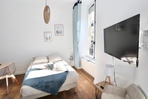a bedroom with a bed and a flat screen tv at Napoléon Gare 1 STUDIO Lumineux ByLocly in Pontivy