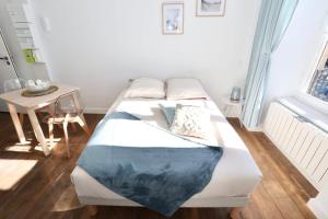 1 dormitorio con cama, mesa y ventana en Napoléon Gare 1 STUDIO Lumineux ByLocly en Pontivy